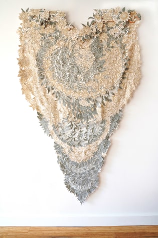 A floral wall hanging made of a curtain with cut cut patterns