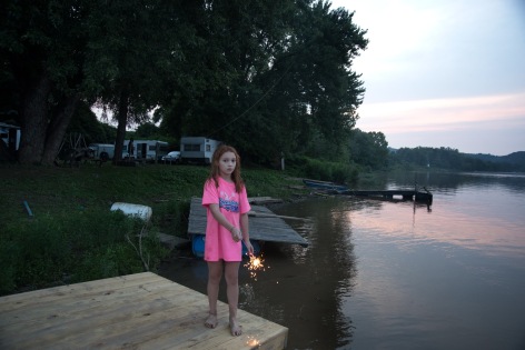 Letart, West Virginia, 2015  Archival Pigment Print  16 x 24 inches, Edition of 7  27 x 40 inches, Edition of 3, Young girl on dock with a spakler, West Virginia
