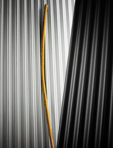 Photograph of tobacco stick against corrugated metal