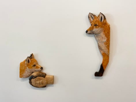 Wooden wall sculpture of face and foxes, by Sachiko Akiyama