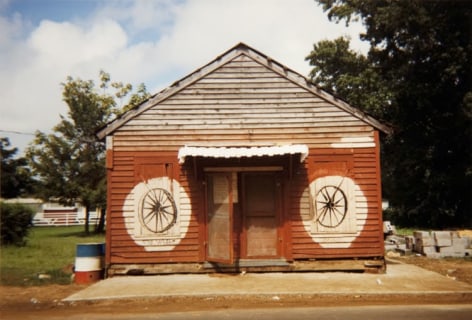 William Christenberry (1936-2016)  Soul Wheel, Greensboro, Alabama, 1977  Ektacolor Brownie Print  3 5/8h x 5w in 9.21h x 12.70w cm  edition of 25 with 5 APs , photograph, facade of red building, with painted circles and a sign that reads Soul Wheel