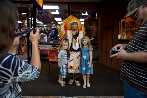 Stacy Kranitz  Gatlinburg, Tennessee, 2016  Archival pigment print  16 x 24 inches, Edition of 7  27 x 40 inches, Edition of 3, Two children and a native american in traditional dress