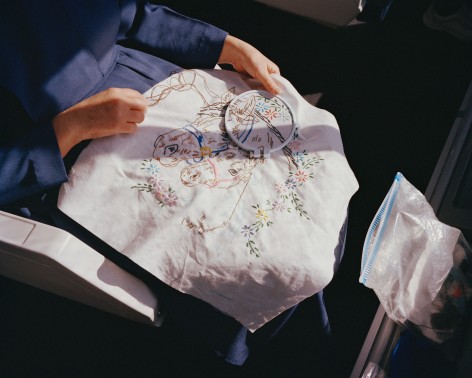 Person with embroidery, by McNair Evans