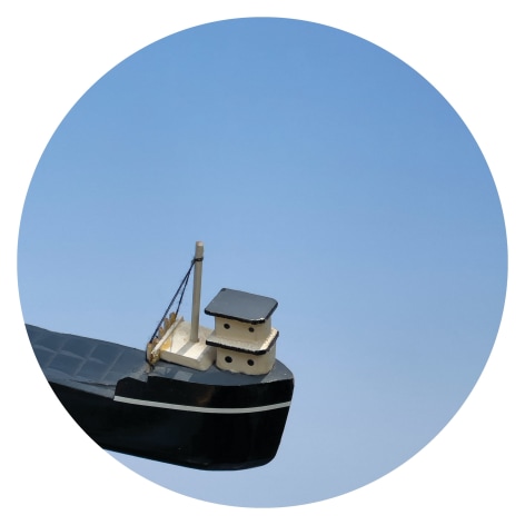 Circular image of toy boat on blue background, by Workingman Collective