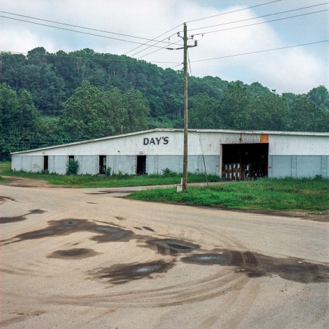 Ken Abbott  Day's Warehouse, Old Lyman St., Asheville, July 2003, Printed 2020  Archival Pigment Print  Images Size: 7 x 7 in Paper Size: 12 x 9 1/2 in Mat Size: 14 x 11 in  Edition of 10  $ 300.00 unframed, photograph of a long grey warehouse