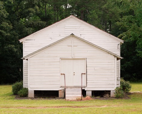 Horizontal photograph if a single room, white, wood slat church
