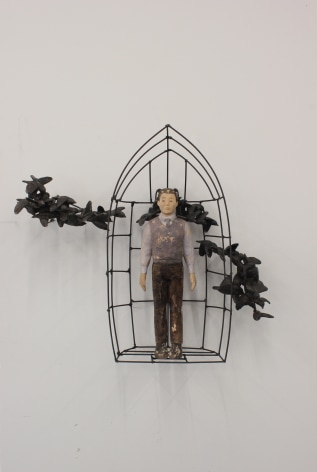 Sachiko Akiyama  Bird by Bird, 2020  wood, metal, paint, resin  22h x 6 1/2w x 20d in. a sculpture resembling a bird cage embellished with strands of birds  with a human figure