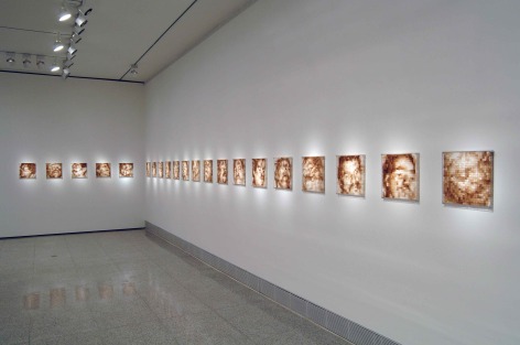 Installation view of Indelible Images exhibition at the Museum of Fine Arts, Houston, 2006. Featuring Oscar Muñoz, Serie Pixeles, set of 9 unique pieces (#1), 1999/2000. Sugar cubes, coffee,  Plexiglass, 13 3/4 x 13 3/4 in.
