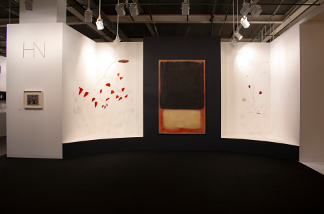Installation view of Art Basel | Basel 2019, booth H5. &copy;Helly Nahmad Gallery NY. Photography by Studio MDA. This photo features the inside of the booth, A latge scale painting by Mark Rothko is in the center, two Calder mobile are suspended from the ceiling on each side. On the left side we can see a small painting by Joan Miro hung on the wall.
