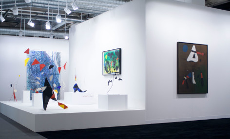Installation view of Art Basel | Basel 2014, booth A8 featuring a brown painting by Joan Miro with a white triangle shape on the top, a blue dot and red elements, the painting is called Composition, was made in 1933 oil on canvas 146.1 x 114.3 centimeters. (57 1/2 x 45 inches.) .  &copy; 2018 Calder Foundation, New York / Artist Right Society (ARS), New York. &copy;Helly Nahmad Gallery NY