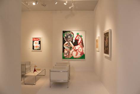 Installation view of Art Basel | Basel 2019, booth H5. &copy;Helly Nahmad Gallery NY. Photography by Studio MDA. This photo features the inside of the booth, we can see a painting by Picasso on the left a small painting by basquiat and on the table a small mobile by Alexander Calder.