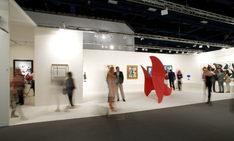 Installation view of Art Basel | Miami Beach 2013, booth B01. This photo depicts the booth from far and the gallery staff and visitors looking at a few paintings and walking around the red large scale Alexander Calder sculpture called Brontosaurus. Photography by Karen Fuchs.  &copy; 2018 Calder Foundation, New York / Artist Right Society (ARS), New York. &copy;Helly Nahmad Gallery NY.