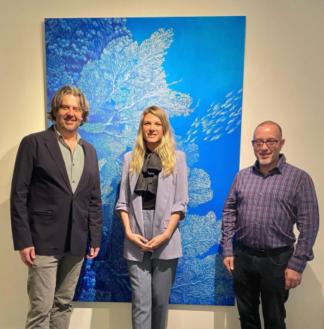 Jay Caldwell, Nikolina Kovalenko and Rob Watt in front of a painting of coral reefs.