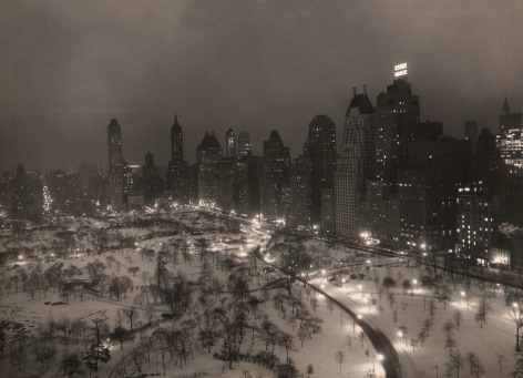 Paul J. Woolf, Central Park Looking Southeast, ​c. 1935. Night time cityscape showing the southeast corner of the park occupying the lower third of the frame with tall buildings, including &quot;Essex House,&quot; surrounding.