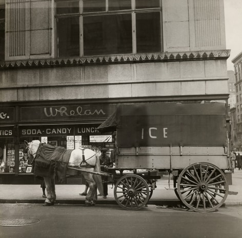 Cecil Beaton, New York, ​c. 1935. A horse-drawn carriage marked &quot;Ice&quot; on the street in front of a building marked &quot;Whelan Soda Candy Lunch&quot;