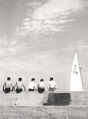 Nino Migliori, Quattro Con, 1955. Five men seated on a wall photographed from the back. A ship's sail is in the right of the frame.