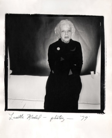 Anthony Barboza, Lisette Model - Photographer, ​1979. Subject stands right-center of the square frame with arms crossed. A black rectangle covers part of the white backdrop.