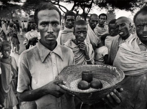 A Week of Provisions: A man holds a week of provisions provided by one of the non-governmental organizations that responded to the famine crisis in Ethiopia, 1984.