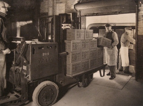 Harold Haliday Costain, Long Island City Plant, 1935. Three men load boxes onto a vehicle.