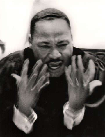 Flip Schulke, Martin Luther King, Jr. Preaching at Ebenezer Baptist Church, ​1963. Subject is blurred in motion with hands gesturing in front of him.