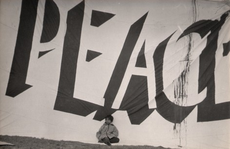 8. LeRoy Henderson, Central Park Anti-Vietnam War Rally, 1968. Young child sits against large banner that reads &quot;PEACE&quot; and fills the frame.