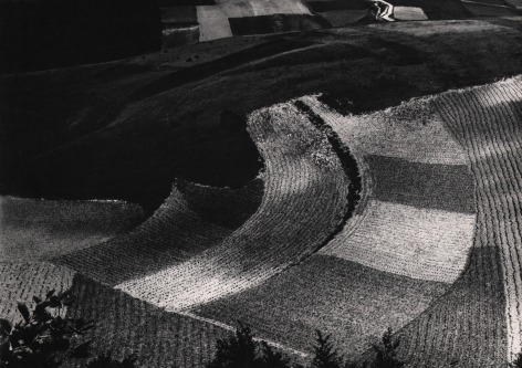 Mario Giacomelli, Metamorphosis of the Land, ​1955&ndash;1968. Dark abstract landscape featuring curved square and rectangular sections of land.
