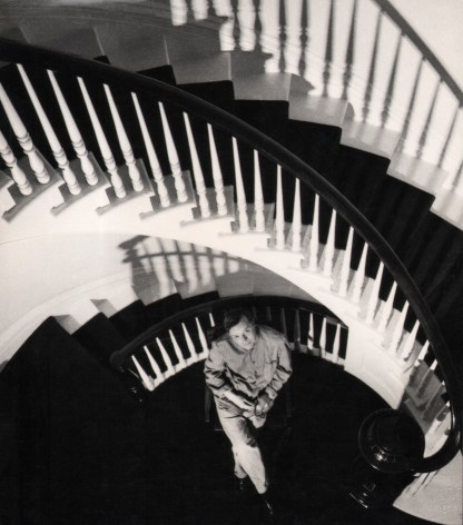 07. David Attie, Truman Capote (Holiday Magazine), 1958. Subject is seated on the landing of a winding staircase, looking up at the camera with legs crossed and hands in his lap.
