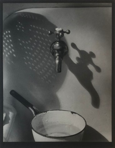 Gordon Coster, The Spigot &amp; the Shadows, ​1927. A white saucepan below a spigot with long shadows going to the right.