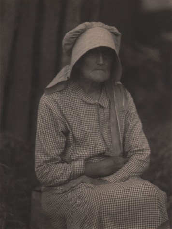 Doris Ulmann, Untitled (Woman in bonnet), ​1928&ndash;1934. Seated woman in checkered dress and large bonnet with arms crossed