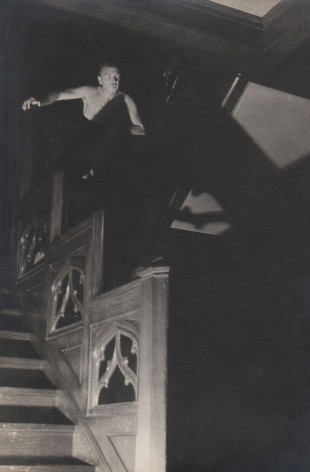 PaJaMa, Jared French, ​c. 1945. A man's upper torso emerges from shadows at the top of a staircase in the top left of the frame.