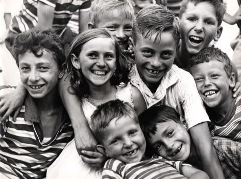 Mario Cattaneo, Untitled, ​c. 1960. A group of seven children huddled close together, smiling to the camera.