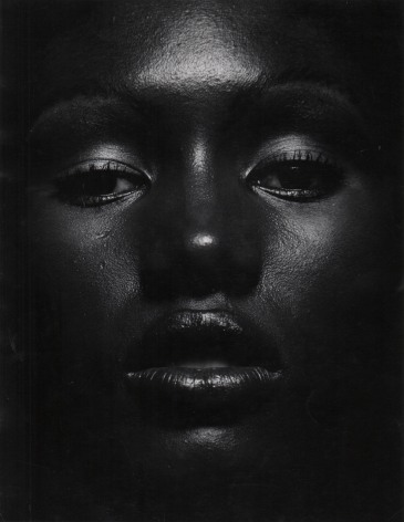 07. Anthony Barboza, Grace Jones, ​1970s. Close up of the model's dimly-lit face, eyes looking to the camera and lips slightly parted.