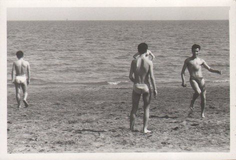 PaJaMa, Untitled, ​c. 1945. Four men in swimsuits stand on the beach. Two face the camera and two face away, towards the ocean.