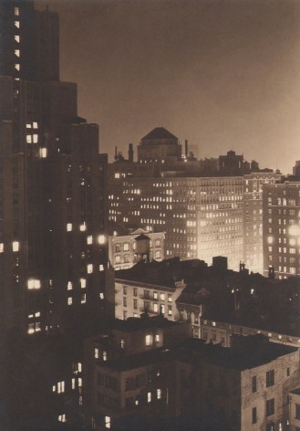Paul J. Woolf, Untitled, ​c. 1933. Night time cityscape above and at the level of the right side buildings, with a taller building occupying the left of the frame.