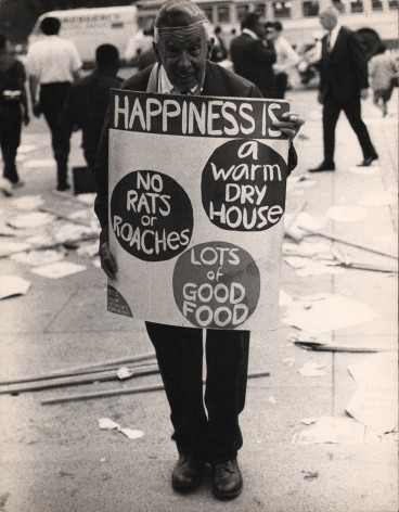9. LeRoy Henderson, Washington, D.C. Poor People's Campaign, ​1968. Older man stands in the street holding a sign that reads &quot;Happiness is: a warm dry house, no rats, or roaches, lots of good food&quot;
