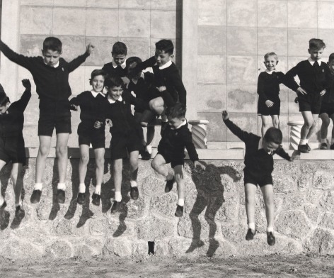 Nino Migliori, People of Emilia, 1957. A group of schoolboys jumping from a low wall.