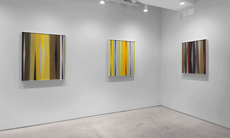 Three paintings by Alice Trumbull Mason installed in the Washburn Gallery comprised of vertical stripes in ochers, grays, blues, blacks, whites, and reds.