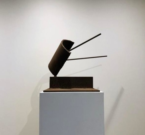 Abstract steel sculpture with brown patina on white base