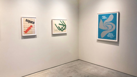 Installation view of three posters by Jack Youngerman.  Red and black graphics, green abstract form, and blue poster with grey form in center advertising &quot;Artists in the Hamptons&quot; exhibition