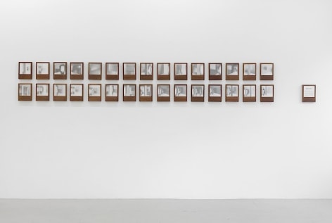 An installation of 30 photo book-objects by Dayanita Singh installed on a white wall