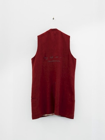 The backside of a cotton, sleeveless knee-length garment, in crimson.