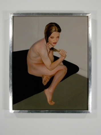 A naked woman clutching her hair, sitting on a black bed in an empty room