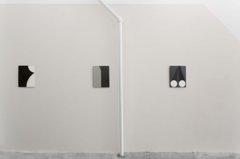 Three enamel paintings on a grey wall