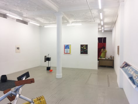 a photograph of the gallery with sculptures on the ground and several works hung on the wall