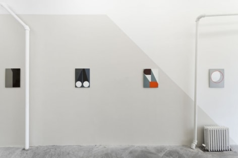 4 enamel paintings hung on a wall. the one work at right is on a white wall, with a diagonal gray cut to the left that takes over the wall.