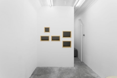 A photograph of 5 black rectangles on the back wall.