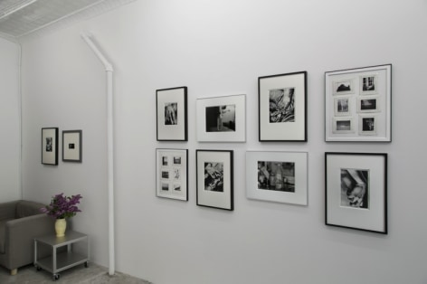 A photograph of 10 image, framed, hung salon style in the gallery.