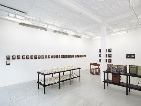An installation view of Dayanita Singh's exhibition, which includes &quot;Pothi Boxes&quot; hung on the wall, &quot;Museum of Gestures,&quot; &quot;File Room book case,&quot; and a custom desk with 2 chairs.