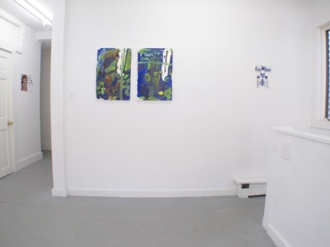 A photograph of 3 images on one wall centrally, and a hallway at left that hosts 1 works