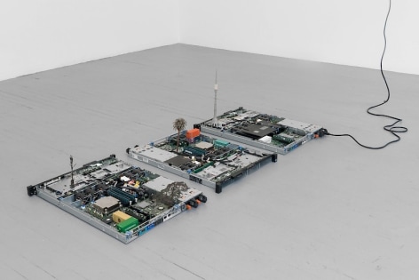 A photograph of 3 circuit board sculptures installed on the ground.